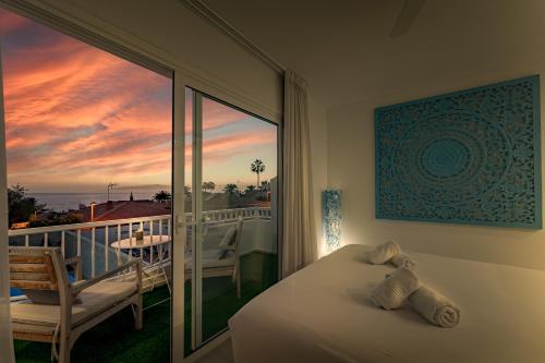 a bedroom with a bed and a balcony with a view at Chill Out House by Olax Rentals in Callao Salvaje