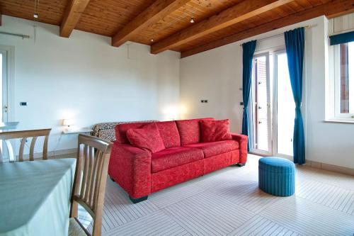 ein Wohnzimmer mit einem roten Sofa und einem Tisch in der Unterkunft SARI CASA VACANZE in Nardò