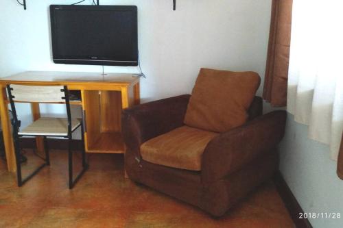 sala de estar con silla y TV en Chochotel Panglao Monaco suite 58sqm en Panglao City