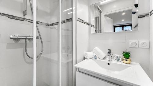 y baño blanco con lavabo y ducha. en HOMEY ARBUSTRO - Petit Studio - Proche frontière et Tram - Wifi en Gaillard