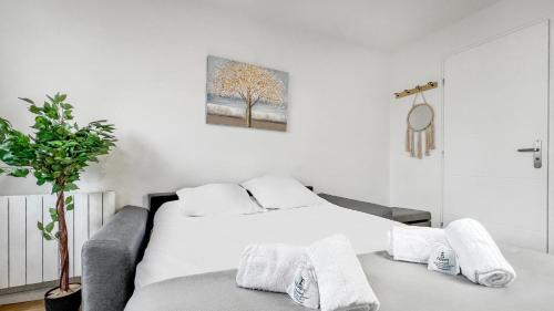 Dormitorio blanco con cama y árbol en HOMEY ARBUSTRO - Petit Studio - Proche frontière et Tram - Wifi en Gaillard