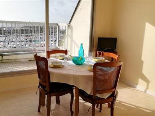 une salle à manger avec une table et des chaises et une fenêtre dans l'établissement Appartement cosy à La Turballe - 2/4 pers, proche centre et plage, parking inclus - FR-1-392-95, à La Turballe