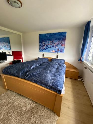 a bedroom with a bed with a blue comforter at Dreisessel Dreiländereck Pool Sauna in Neureichenau