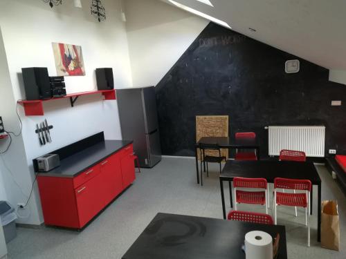 uma sala de jantar com armários vermelhos e uma parede preta em 25 Hours Hostel em Vilnius