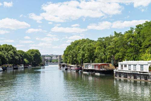 a river with several boats on the water at Escale Sur Seine in Paris