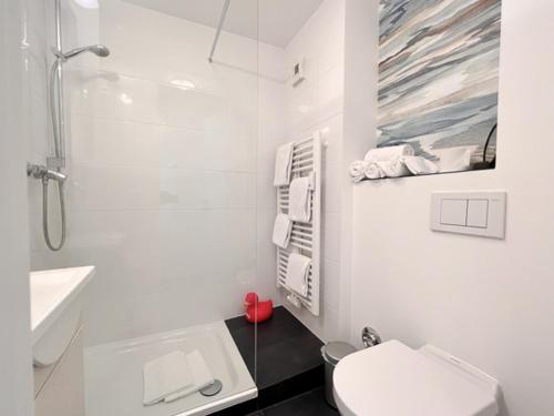 a white bathroom with a toilet and a sink at Duen12 21 Magic Beach in Westerland