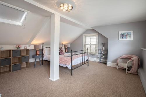 um quarto com uma cama e uma cadeira num quarto em Cosy Cottage in Lytham St Annes - close to beach em Saint Annes on the Sea