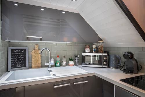 a kitchen with a sink and a microwave at Cosy Cottage in Lytham St Annes - close to beach in Saint Annes on the Sea