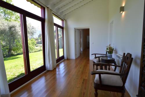 a hallway with a table and chairs and large windows at Casa de Cartemil in Ponte de Lima