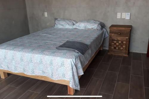 een slaapkamer met een bed en een houten nachtkastje bij Lees' Beach House in Garita