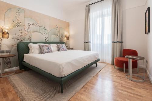 1 dormitorio con 1 cama grande y 1 silla roja en Be Mate Trastevere II, en Roma