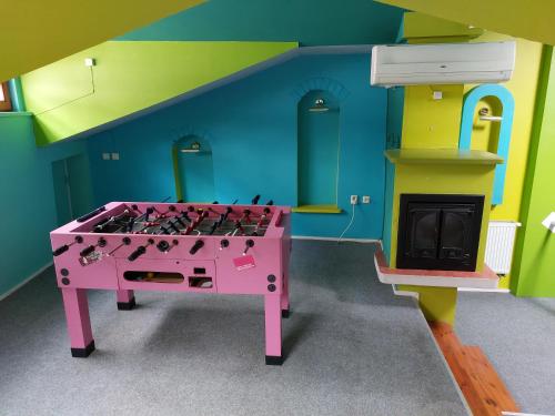 um quarto lego com uma mesa rosa e uma lareira em 25 Hours Hostel em Vilnius
