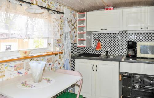 a small kitchen with white cabinets and a table at 1 Bedroom Lovely Home In Kristinehamn in Edet