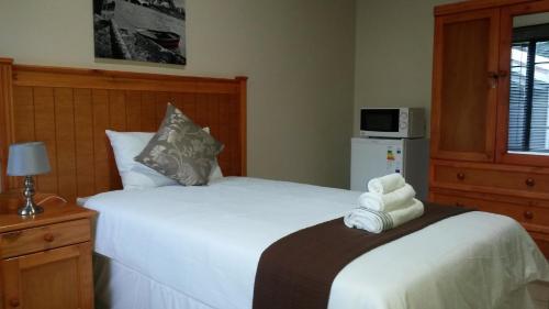 a hotel room with two beds and a microwave at Eagles Nest Guesthouse in Eshowe