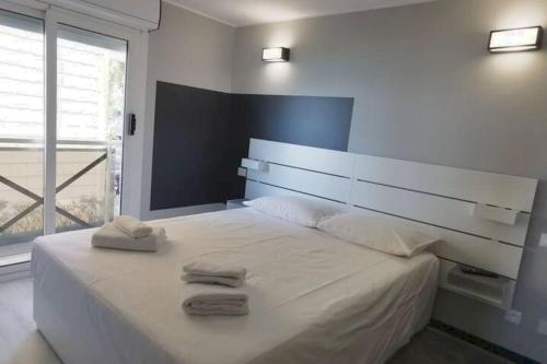 une chambre avec un grand lit blanc avec des serviettes dessus dans l'établissement Bellaviste trilocale vista mare, à Menton