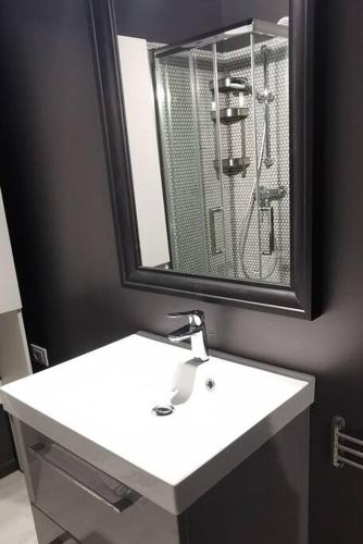 une salle de bain avec un lavabo blanc et un miroir dans l'établissement Bellaviste trilocale vista mare, à Menton