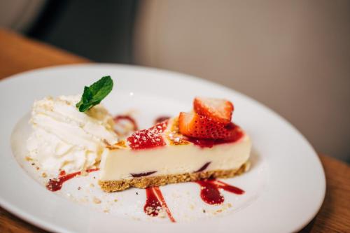 a piece of cake with strawberries and whipped cream on a plate at ibis Coleraine Riverside in Coleraine