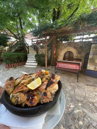 a chicken in a pan with a lemon on a table at Rooms Merlika -Inside the Castle- in Krujë