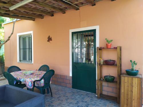 eine Terrasse mit einem Tisch und einer grünen Tür in der Unterkunft Il Vigneto "Cottage" in Gaggi