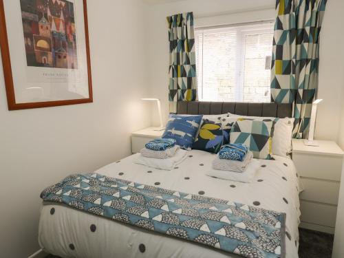 a bedroom with a bed with pillows and a window at Lynton House in Hebden Bridge
