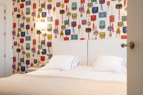 a bedroom with a bed with a wall covered in stickers at Hotel Made In Louise in Brussels
