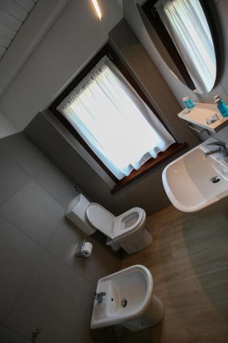 a bathroom with a sink and a toilet and a window at Appartamento immerso nella natura con parcheggio - Primula in Sòis