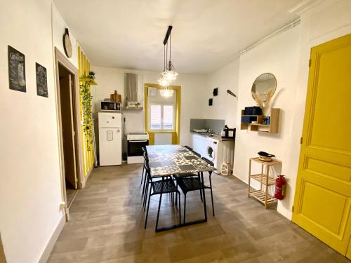 eine Küche mit einem Tisch und Stühlen im Zimmer in der Unterkunft L'appart & de la Turdine à L'arbresle entrée autonome in Éveux