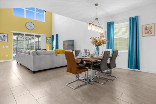 a dining room and living room with a table and chairs at Stylish Resort Villa w Pool Near Disney Gated 5BR in Kissimmee