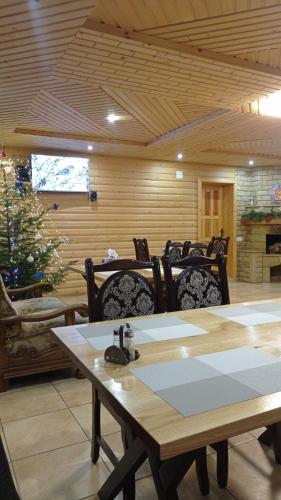 a room with a table and chairs and a christmas tree at Villa Filiak in Yablunytsya