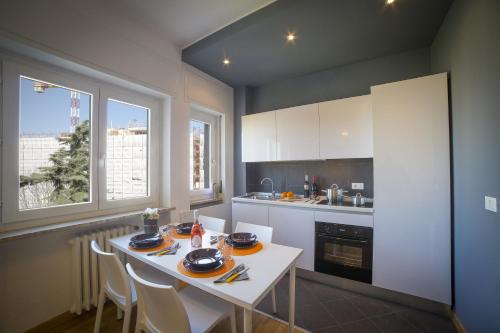 a kitchen with a white table and chairs and two windows at Dreams Hotel Residenza Gambara in Milan