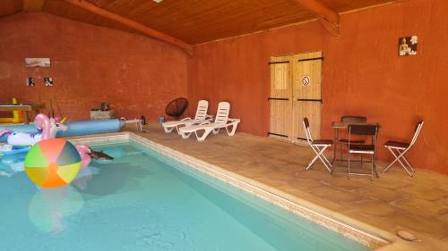 - une piscine avec une table, des chaises et un ballon dans l'établissement les gîtes d 'EVANE 