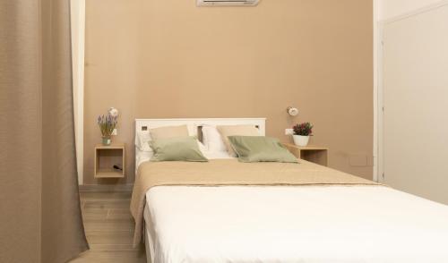 una camera da letto con un letto bianco con cuscini verdi di Terre d'aMare Liguria a La Spezia