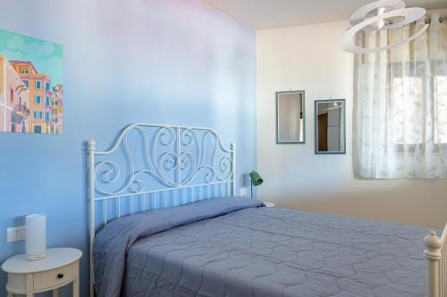 1 dormitorio con 1 cama con colcha azul en GraziellaHouse, en Brenzone sul Garda