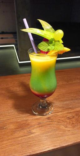a green drink with a straw in a glass on a table at Dwór w Zabużu in Zabuże