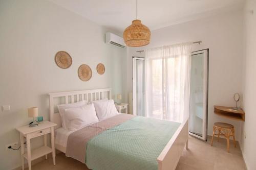 une chambre blanche avec un lit et une fenêtre dans l'établissement Charming Sweet Apt @Garitsa!, à Corfou
