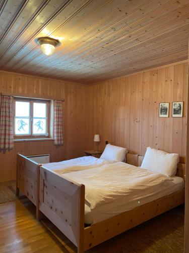 a bedroom with a large bed in a wooden room at Alpengasthof Crusch Alba ed Alvetern, S-charl in Scuol