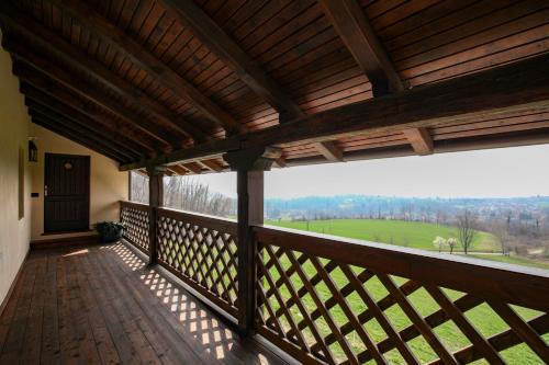a wooden balcony with a view of a green field at Appartamento immerso nella natura con parcheggio - Stella Alpina in Sòis