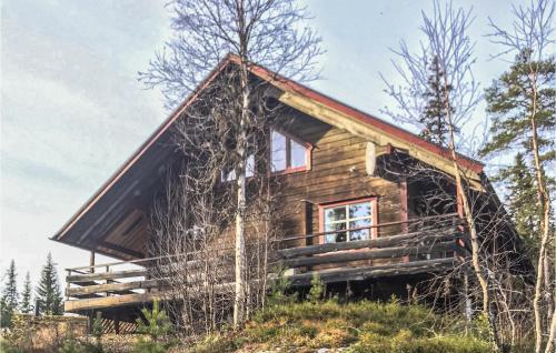 une cabane en rondins sur une colline plantée d'arbres dans l'établissement Cozy Home In Srna With Kitchen, à Fjätervålen