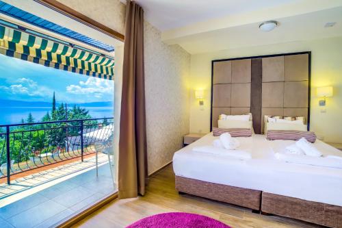 a bedroom with a large bed and a large window at Vila Bisera in Ohrid