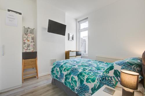 a bedroom with a bed with a blue and white blanket at Pass the Keys City Beach flat next to the sea sleeps up to 6 in Southend-on-Sea