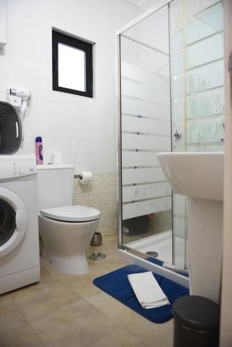 y baño con aseo, ducha y lavamanos. en Cartaia Apartamento Leste, en Quarteira