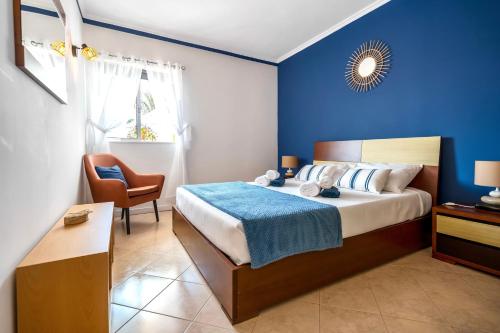 ein Schlafzimmer mit einem Bett und einer blauen Wand in der Unterkunft Villa PACA Algarve Vilamoura 8 personnes in Quarteira
