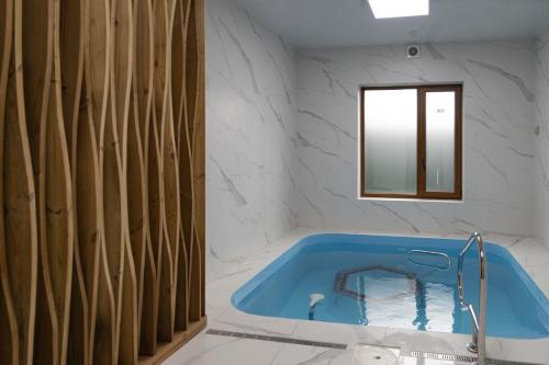 a bathroom with a blue tub and a mirror at President Hotel&Restaurant&SPA in Trostyanets