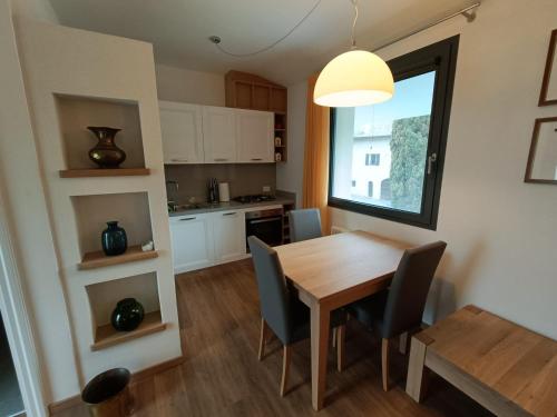 een keuken en eetkamer met een houten tafel en stoelen bij Appartamento Popone 1 in Aquiléia