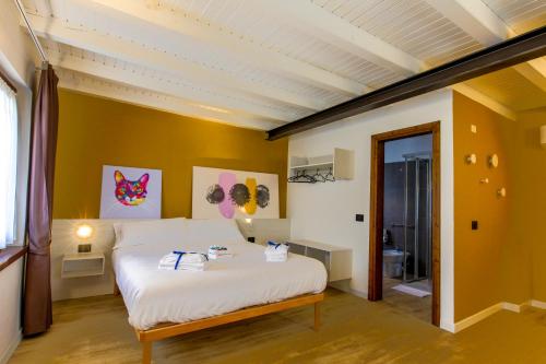 1 dormitorio con cama blanca y paredes amarillas en Le Tofane, vivi la bellezza di Belluno - Narciso, en Sòis
