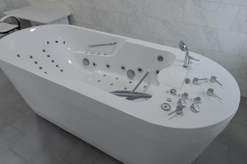 a white bath tub in a white bathroom at President Hotel&Restaurant&SPA in Trostyanets