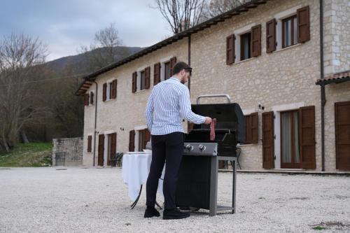 a man standing in front of a grill at Country House Elite in Cascia