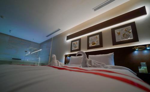 a bedroom with a large bed with white sheets at فندق سنبات بلاتينيوم in Jazan