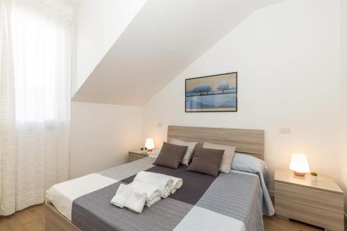 Habitación blanca con cama grande con almohadas en Casa Olivastro Millenario B, en Santa Maria Navarrese