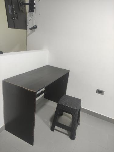 a black desk with a stool in a room at Aparta-hotel norte de Tunja in Tunja
